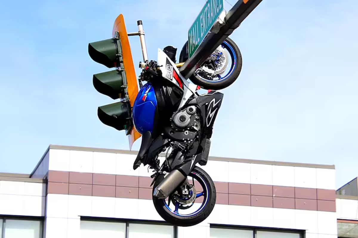 Canadá. ele colidiu com o carro, voou e a moto acabou pendurada no semáforo.